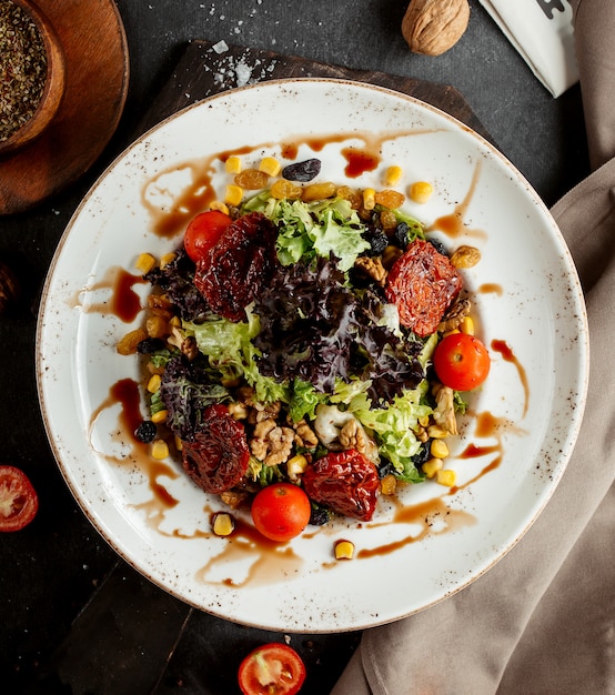 Kostenloses Foto draufsicht des gemüsesalats mit salatmais-walnusskirsche und getrockneten tomaten