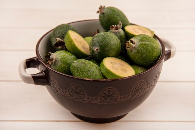 Draufsicht des gesunden grünen Feijoa auf einer Schüssel auf einer weißen Holzoberfläche