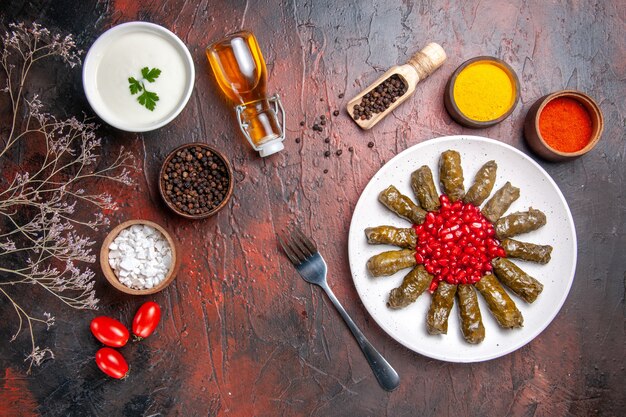 Draufsicht des grünen Blattdolmas mit Gewürzen auf der dunklen Oberfläche