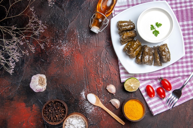 Draufsicht des grünen Blattdolmas mit Joghurt auf der dunklen Oberfläche