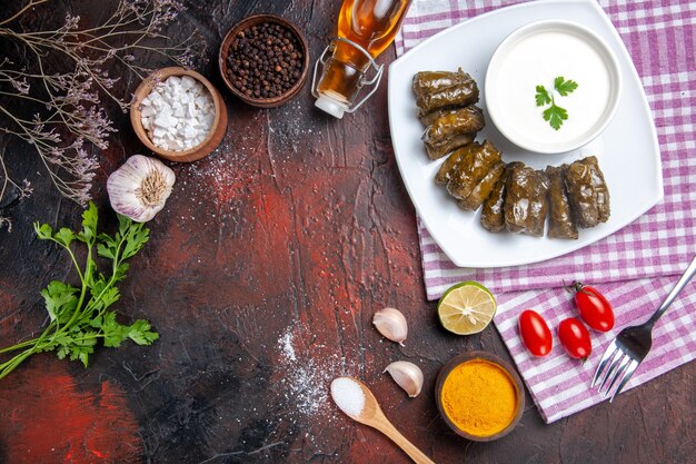 Draufsicht des grünen Blattdolmas mit Joghurt auf der dunklen Oberfläche