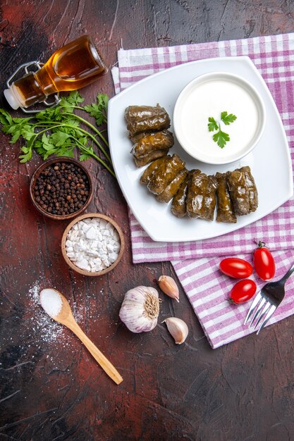 Draufsicht des grünen Blattdolmas mit Joghurt auf der dunklen Oberfläche