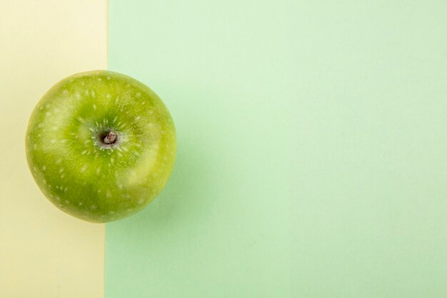 Draufsicht des grünen und frischen Apfels auf gelber und grüner Oberfläche