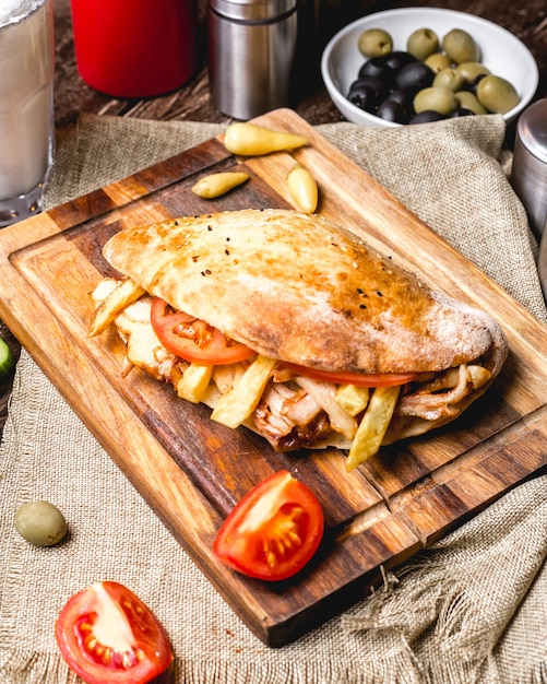 Draufsicht des Hühnerdoners mit Tomaten-Pommes und Gurken