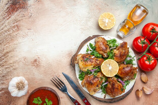 Draufsicht des Hühnersauceöl-Tomaten-Knoblauch-Zitronen-Huhns mit Kräutergabelmesser