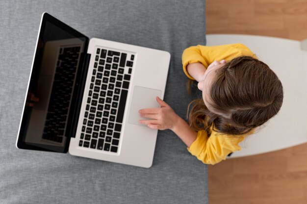 Draufsicht des kleinen Mädchens unter Verwendung des Laptops