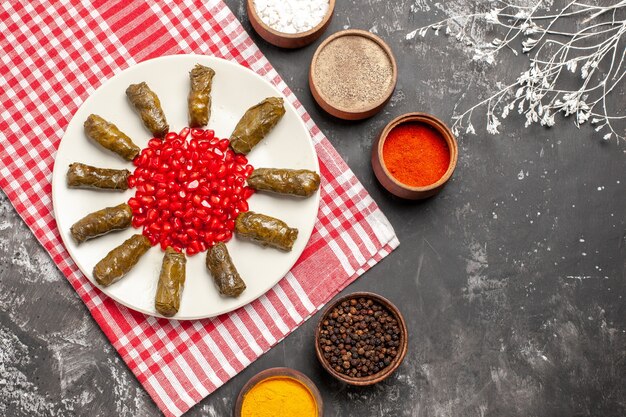 Draufsicht des köstlichen Blattdolmas mit Gewürzen auf dunkler Oberfläche