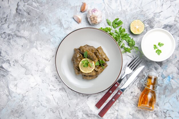 Draufsicht des köstlichen Blattdolmas mit Knoblauch auf weißer Oberfläche