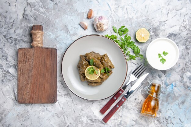 Draufsicht des köstlichen Blattdolmas mit Knoblauch auf weißer Oberfläche