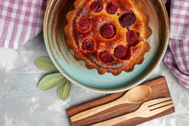 Draufsicht des köstlichen Obstkuchens mit gebackenen Himbeeren innen auf leichtem süßem Tee des Kuchenbackens