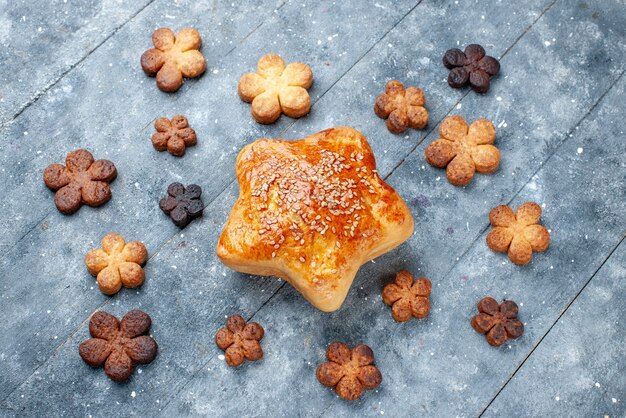 Draufsicht des köstlichen süßen Gebäcksterns geformt mit Keksen auf grauem, süßem Backgebäckkuchen