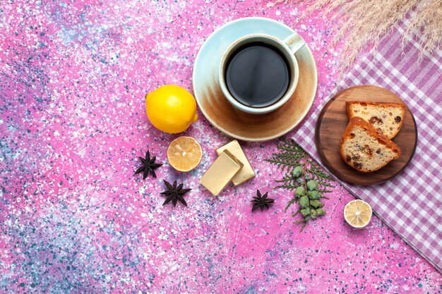 Draufsicht des leckeren Kuchens, der mit Tasse Tee und Zitronen auf hellrosa Oberfläche geschnitten wird