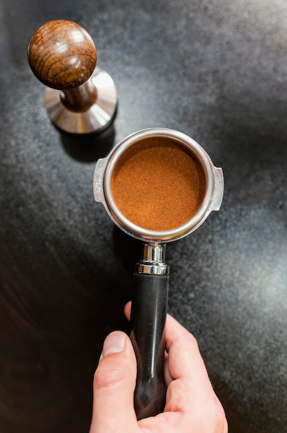 Kostenloses Foto draufsicht des männlichen barista, der professionelle kaffeemaschinenschale hält