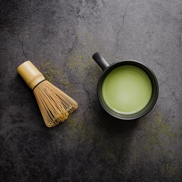 Draufsicht des matcha Tees in der Schale mit Bambus wischen