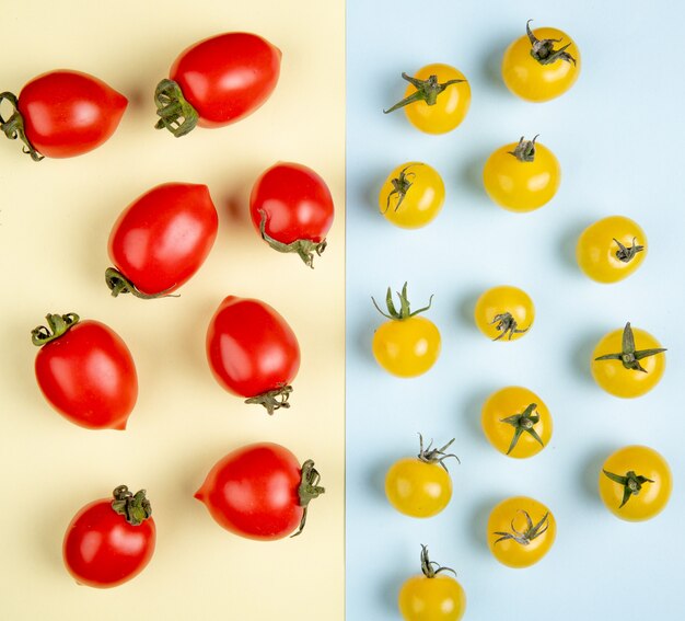 Draufsicht des Musters der roten und gelben Tomaten auf gelber und blauer Oberfläche