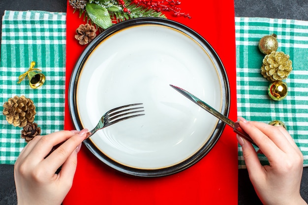 Draufsicht des nationalen Weihnachtsmahlzeithintergrundes mit leeren Plattenbesteck-Satzdekorationszubehör auf grünem abgestreiftem Handtuch