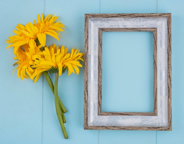 Draufsicht des rahmens mit blumen auf blau mit kopienraum