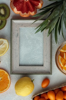 Draufsicht des rahmens mit früchten wie grapefruit-zitronen-orangen-kumquat mit ananasblättern auf weißem hintergrund