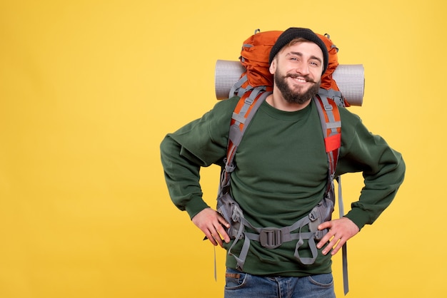 Draufsicht des Reisekonzepts mit dem lächelnden glücklichen jungen Mann mit Packpack