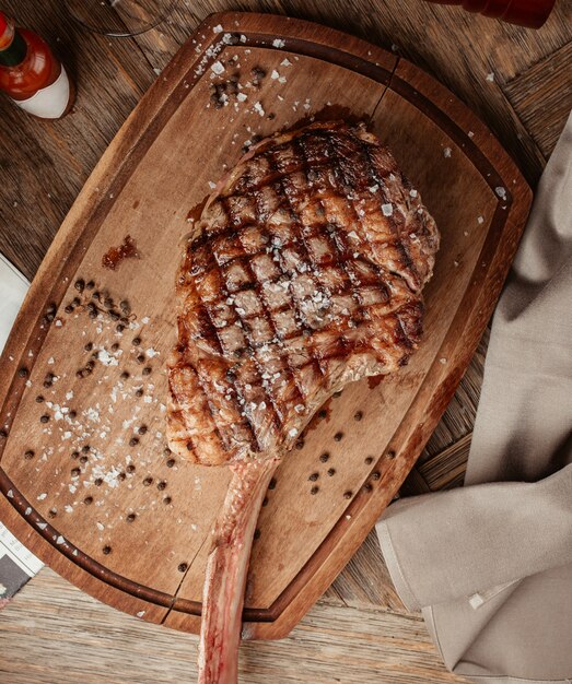 Draufsicht des Ribeye-Steaks, das auf Holzbrett serviert wird