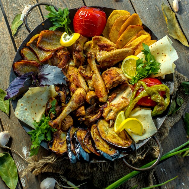 Draufsicht des Saj Kebab der traditionellen kaukasischen Küche mit Hühnereierplänen Tomaten Kartoffeln und Paprika