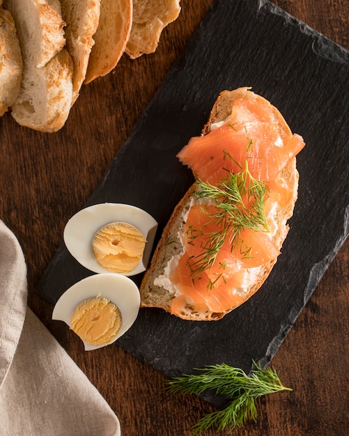 Draufsicht des Sandwichs auf Schiefer mit Lachs und hart gekochtem Ei