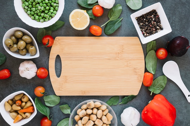 Draufsicht des Schneidebretts mit Kirschtomaten und Spinat