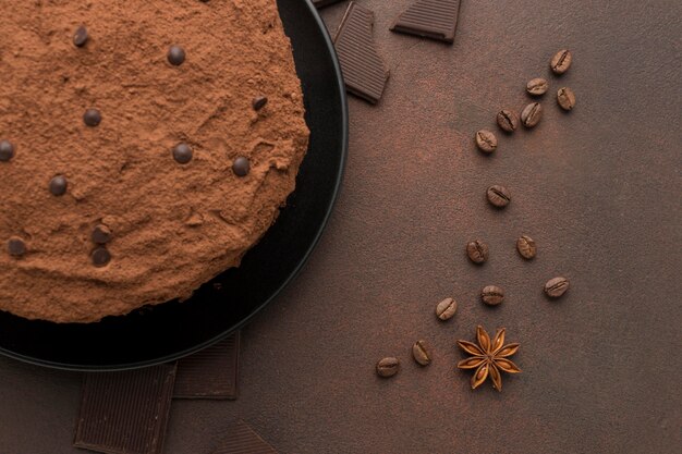 Draufsicht des Schokoladenkuchens mit Kakaopulver und Kaffeebohnen