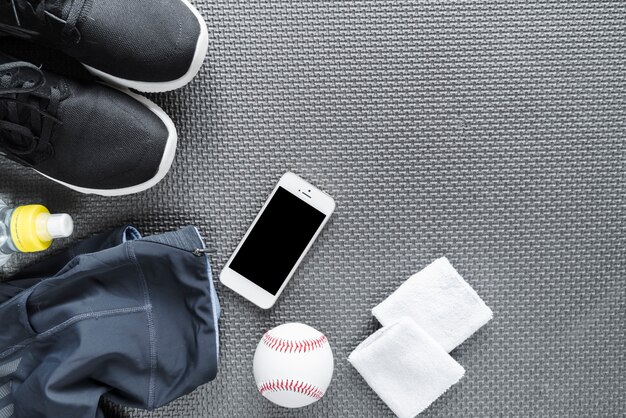 Draufsicht des Smartphone umgeben mit Sportkleidung
