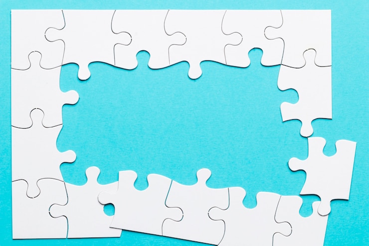Kostenlose Foto draufsicht des unvollständigen puzzlespielrahmens über blauem hintergrund