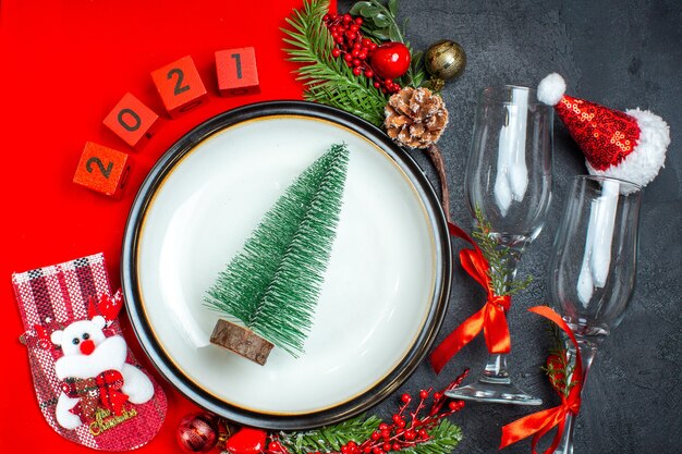 Draufsicht des Weihnachtsbaums auf einem Teller nummeriert Glasbecher-Weihnachtssocke auf dunklem Hintergrund