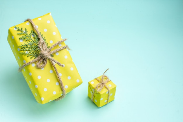 Draufsicht des Weihnachtshintergrundes mit gelben Geschenkboxen auf pastellgrünem Hintergrund