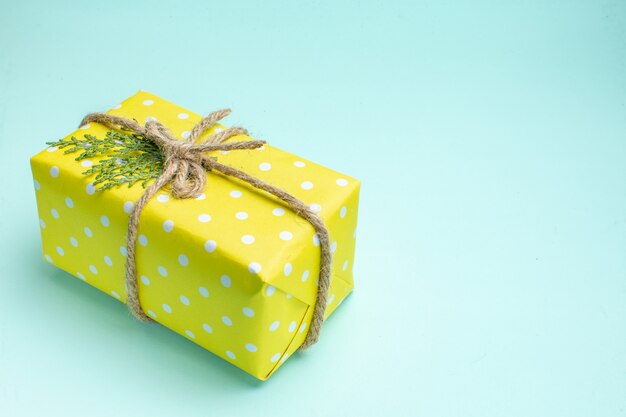 Draufsicht des Weihnachtshintergrundes mit gelber Geschenkbox auf pastellgrünem Hintergrund