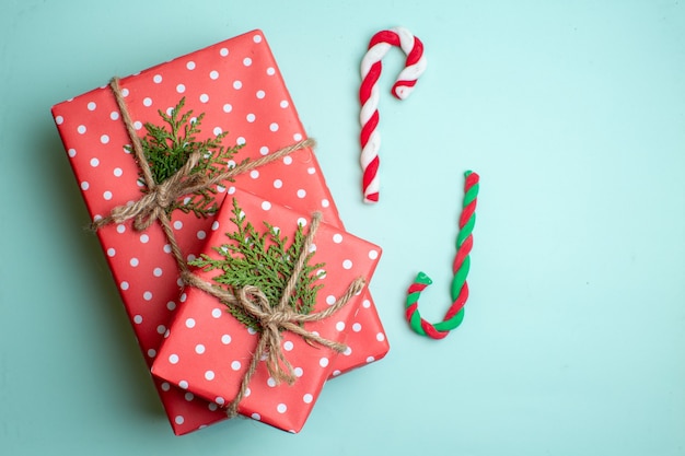 Draufsicht des Weihnachtshintergrundes mit Geschenkboxen und Bonbons auf pastellgrünem Hintergrund