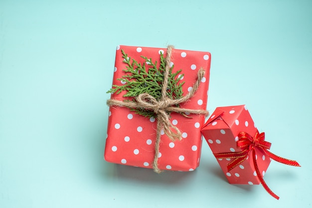 Draufsicht des Weihnachtshintergrundes mit roten Geschenkboxen auf pastellgrünem Hintergrund