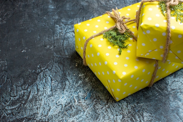 Draufsicht des Weihnachtshintergrundes mit schönen gelben Geschenkboxen auf der rechten Seite auf dunklem Hintergrund