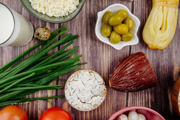 Draufsicht des Ziegenkäses mit geräucherter Käse-Frühlingszwiebel und eingelegten Oliven auf rustikalem Holz