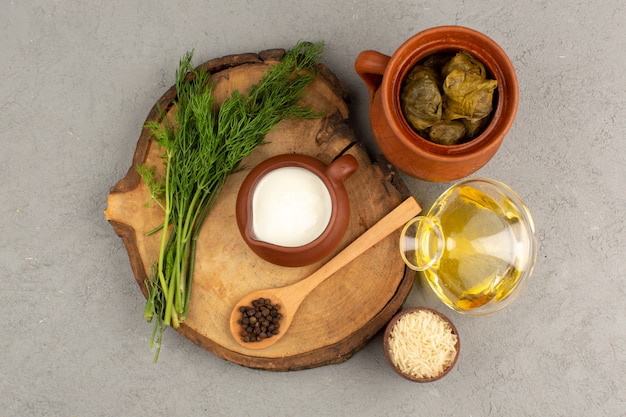 Draufsicht Dolma grün zusammen mit Joghurt und Olivenöl auf dem Grau