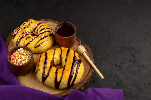 Draufsicht Donuts mit Schokolade lecker lecker auf dem braunen Schreibtisch und grauem Hintergrund