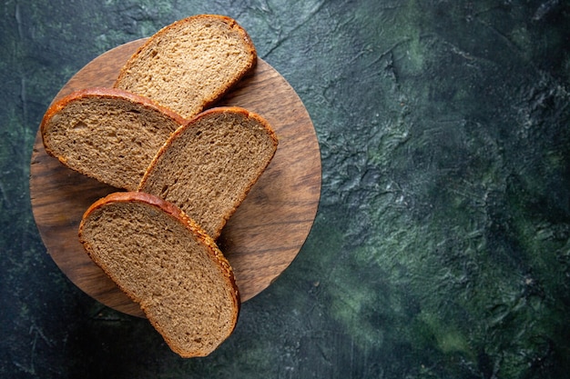 Draufsicht dunkle Brotlaibe auf dunklem Schreibtisch