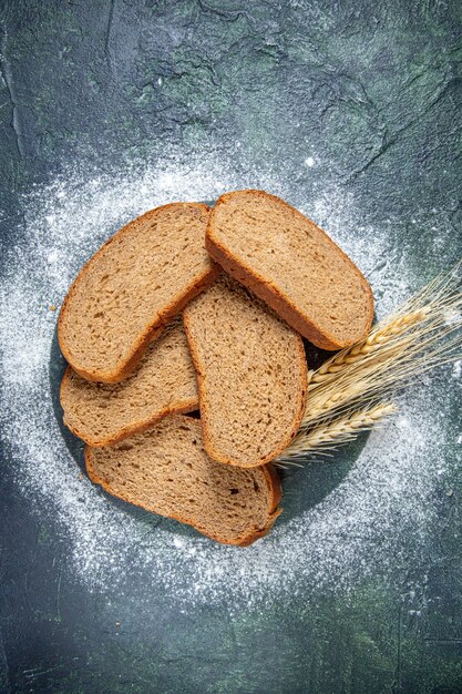 Draufsicht dunkle Brotlaibe auf dunklem Schreibtisch