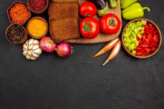 Draufsicht dunkle Brotlaibe mit Gewürzen Tomaten und Auberginen auf dunklem Hintergrund Salat Gesundheit reife Mahlzeit Gemüse Diät