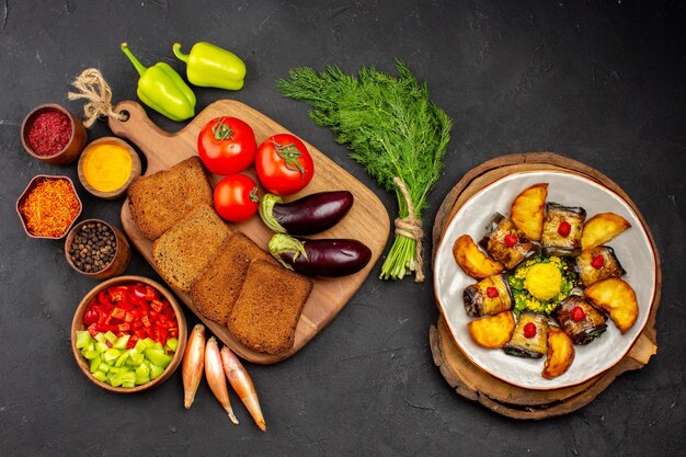 Draufsicht dunkle Brotlaibe mit Gewürztomaten und Auberginen auf dem dunklen Hintergrund Salat Gesundheit reife Mahlzeit