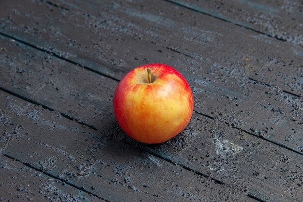 Draufsicht ein Apfel gelb-rötlicher Apfel auf einem grauen Holztisch