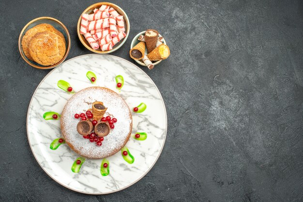 Draufsicht ein Kuchen ein appetitlicher Kuchen mit Beerenschalen von Keksen bunte Bonbons Waffeln