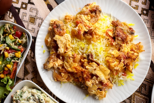 Draufsicht ein traditionelles aserbaidschanisches Gericht Chyhyrtma Pilaw gebratenes Huhn mit Omelett und Reis
