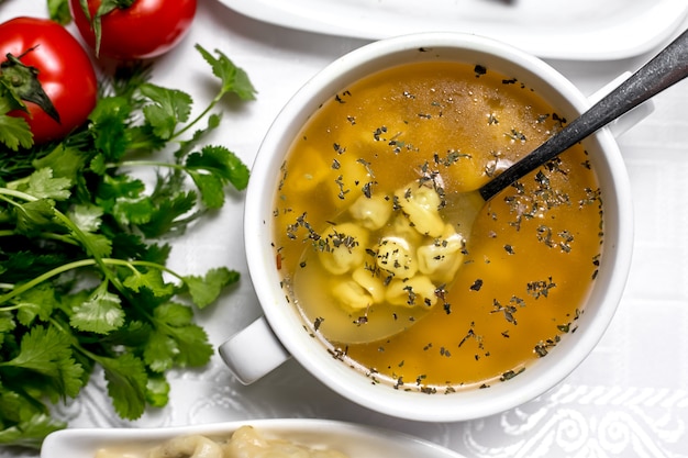 Draufsicht ein traditionelles aserbaidschanisches Gericht Dushbara mit Petersilie und Tomaten