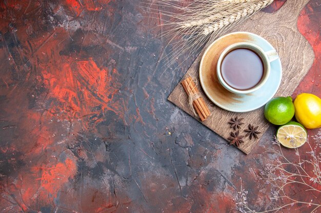 Draufsicht eine Tasse Tee eine Tasse Tee Sternanis Zitrone Limette Zimt auf dem Brett