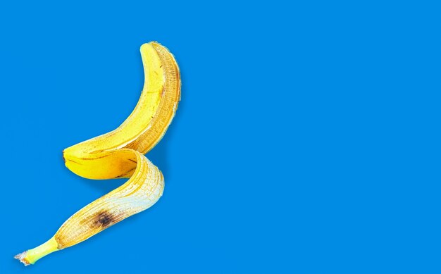 Draufsicht einer gelben Bananenschale, die auf einer blauen Oberfläche liegt