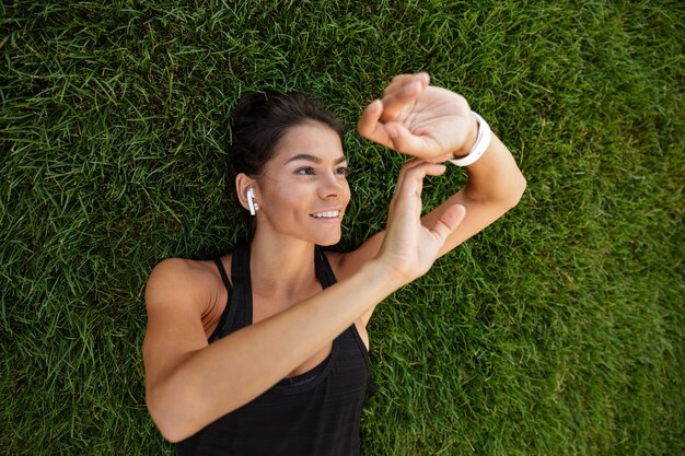 Draufsicht einer glücklichen Fitnessfrau in den Kopfhörern